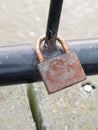 Old rusty padlock up close locked on black metal gate Royalty Free Stock Photo