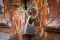 Old rusty padlock on wooden close up. Peeling paint door. Old wood door texture. Close up view old lock.