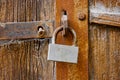 Old rusty padlock on wooden gates. An obsolete lock hangs on the weathered door. Royalty Free Stock Photo