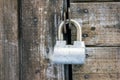 Old rusty painted metal padlock on wooden board door closeup Royalty Free Stock Photo