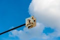 Old, rusty pedestrian crossing street sign close up shot, blue sky with white clouds