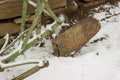 Old rusty plough in snow and wooden cabin