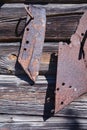 Old rusty plow blade on gray wooden barn wall