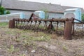 Old rusty plow near a fence