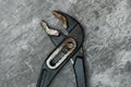 Old and rusty plumbing pliers on concrete floor