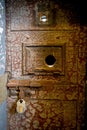 Old rusty prison door with a lock