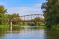 Old rusty railway bridge over river on a blue sky background. River landscape at sunny autumn morning Royalty Free Stock Photo