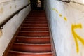 Rusty red stairs between weathered white walls with yellow arrows directions Royalty Free Stock Photo