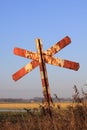 Old and rusty red and white railroad cross signpost Royalty Free Stock Photo