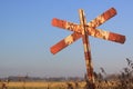 Old and rusty red and white railroad cross signpost Royalty Free Stock Photo