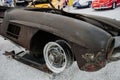 Old rusty retro car bumper lies on the white rock surface in the auto show Royalty Free Stock Photo