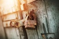 An old rusty retro padlock hangs on an old wooden gate, painted with blue paint. The secret is behind closed doors Royalty Free Stock Photo