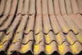 Old rusty roof with yellow moss. Home coverage. Selective focus texture of brown corrugated slate. Royalty Free Stock Photo