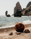 Old rusty round floating marine mines on the beach with rocky shore and sea background.