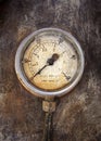 Old rusty round industrial pressure gauge with numbers round the dial