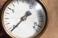 Old rusty round industrial pressure gauge with numbers on a white dial. Royalty Free Stock Photo