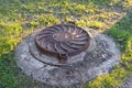 Old rusty round sewage hatchway on the lawn