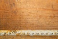 Old rusty ruler with black numbers on a working wooden table. vintage measuring tape. industrial background Royalty Free Stock Photo