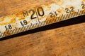 Old rusty ruler with black numbers on a working wooden table. vintage measuring tape. industrial background Royalty Free Stock Photo