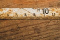 Old rusty ruler with black numbers on a working wooden table. vintage measuring tape. industrial background Royalty Free Stock Photo