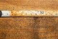 Old rusty ruler with black numbers on a working wooden table. vintage measuring tape. industrial background Royalty Free Stock Photo