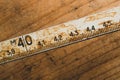 Old rusty ruler with black numbers on a working wooden table. vintage measuring tape. industrial background Royalty Free Stock Photo