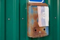 old rusty russian mailbox on the wall with extremely faded small fabric russian flag with with coat of arms