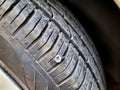 old rusty screw or nail inside a car tyre that caused a damage and the tire need to be fixed or replaced, car mechanic service Royalty Free Stock Photo