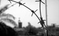 Old rusty security barbed wire fence on blue sky