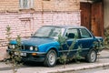 Old rusty sedan car BMW 3 Series, E30, parking on street. The BMW Royalty Free Stock Photo