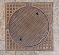 Old rusty sewer hatch on an old metal plate. View from above