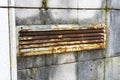 Old rusty shabby ventilation grill on a mossy tiled wall Royalty Free Stock Photo