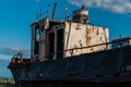 old rusty ship, boat on grassy shore in light of sunset, white vessel on coast of lake Baikal, blue Royalty Free Stock Photo