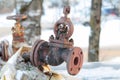 Old rusty shut-off valve on a heating pipe on a winter background