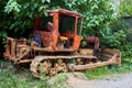 Old rusty soviet tractor, standing in the grass