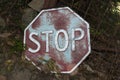 Old rusty Stop sign lying forgotten on the ground in the countryside Royalty Free Stock Photo