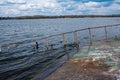 Old rusty sunken pier in the water on the territory of the river port. Royalty Free Stock Photo