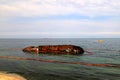 An old rusty tanker flooded and lies in Odessa, Ukraine. Oil spills from the ship and pollutes the sea water. Environmental