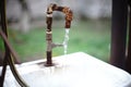 Old rusty tap on a sink with flowing water in a rural yard Royalty Free Stock Photo