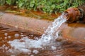 An old rusty tap from which an artificial lake is filled. Rusty sediment at the bottom of the lake Royalty Free Stock Photo