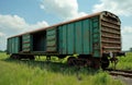 Old rusty teal freight car sits on train tracks in a grassy field. The wagon doors are open revealing empty interior. Sky has Royalty Free Stock Photo