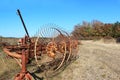 Old rusty tedder standing on a dry field Royalty Free Stock Photo