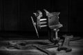 Old rusty tool in the dark room, totally dark place, playing with lights, old stuff, vice, keys on wooden table, black and white p Royalty Free Stock Photo