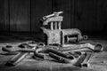 Old rusty tool in the dark room, totally dark place, playing with lights, old stuff, vice, keys on wooden table, black and white p Royalty Free Stock Photo