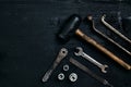 Old, rusty tools lying on a black wooden table. Hammer, chisel, metal scissors, wrench. Royalty Free Stock Photo