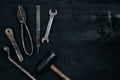 Old, rusty tools lying on a black wooden table. Hammer, chisel, metal scissors, wrench. Royalty Free Stock Photo