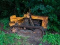 Old rusty track tractor abandoned and surrounded by vegetation