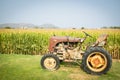 Old and rusty tractor on a corn field landscape Royalty Free Stock Photo