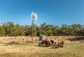 Old rusty tractor and a windmill on the backroads of Texas Royalty Free Stock Photo