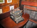 Old rusty typewriter sitting on dusty wooden table in the cabin of an antique wooden boat - very Hemingwayesque